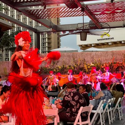 a group of people performing on stage in front of a building