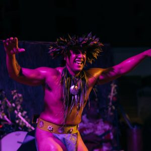 a person holding a purple flower on a stage