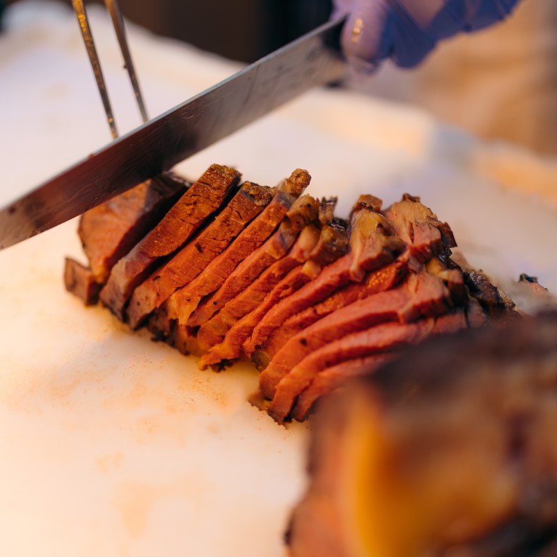 a plate with a fork and knife on a cutting board with a cake